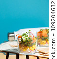healthy salad in a glass cup. Pieces of fresh vegetables, micro-greens and corn. Close-up, aesthetics. 109204632