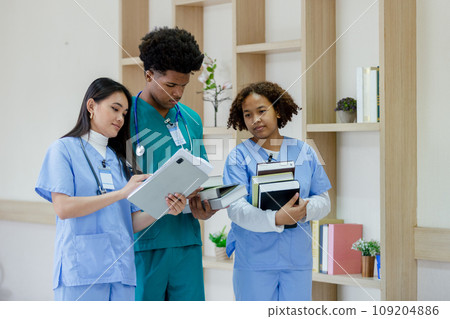 Group of medical student holding book walking front classroom in hospital university. 109204886