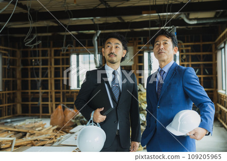 A man in a suit looking at materials at a skeleton property 109205965