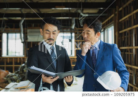 A man in a suit looking at materials at a skeleton property A man in a suit looking at materials at a skeleton property 109205975