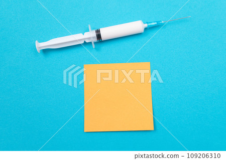 Vaccination or Revaccination Concept - A Medical Syringe on Blue Table 109206310