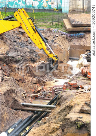 the excavator is working on emergency work to repair the pipeline, a breakthrough in the water supply and heating pipeline.  selective focus, copy space 109206745