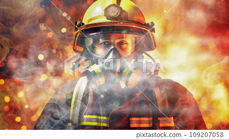 firefighter in an oxygen mask and safety glasses against the background of a bright flame of fire and smoke firefighter in an oxygen mask and safety glasses against the background of a bright flame of fire and smoke 109207058