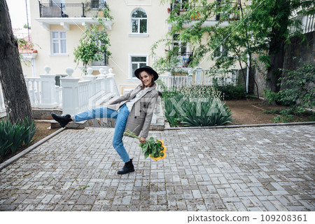 Woman in a hat with flowers posing for a walk near the house 109208361