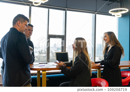Professionals gather around table at meeting with Shih Tzu 109208719