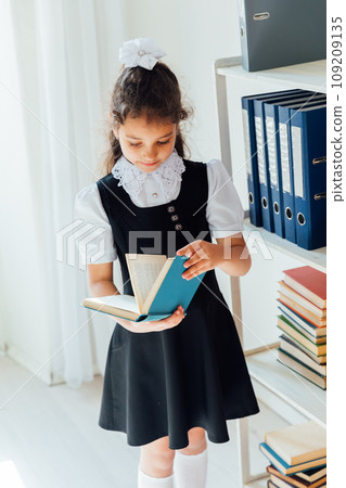 Schoolgirl girl reading a book at lesson Schoolgirl girl reading a book at lesson 109209135