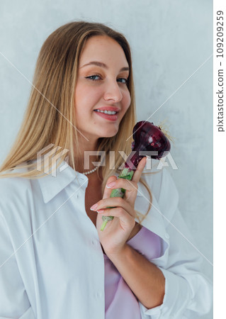 woman nutritionist holding onions in her hands woman nutritionist holding onions in her hands 109209259