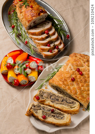 Traditional festive Christmas dishes on the table. Wellington with mushrooms, stuffed turkey roll 109210424