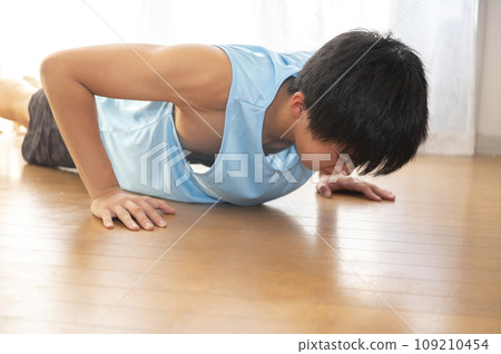 Teenage man training his legs at home Teenage man training his legs at home 109210454