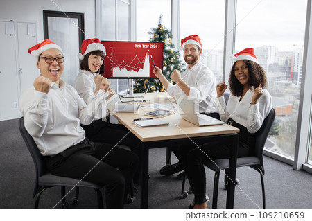 Team of business people in Santa hats raising hands Team of business people in Santa hats raising hands 109210659