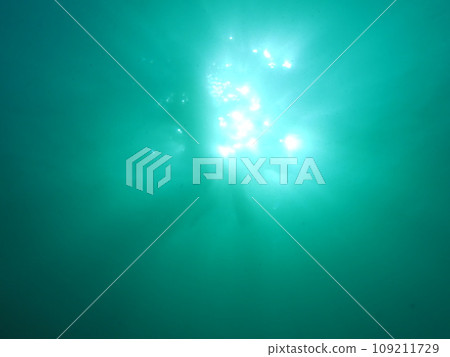 The sun and diver seen from underwater 109211729