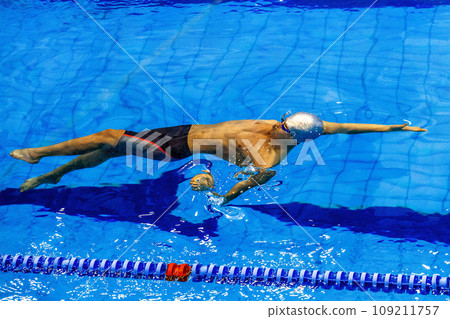 male swimmer swim backstroke in competition race, summer sports games 109211757