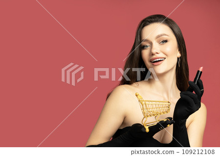 A girl with a shopping basket and lipstick in her hands 109212108