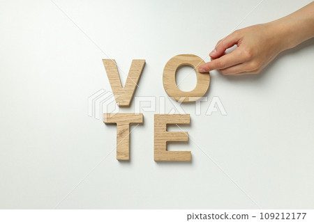Word Vote from wooden letters and hand on white background, top view 109212177
