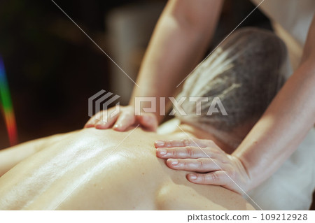 Medical massage therapist in massage cabinet massaging client Medical massage therapist in massage cabinet massaging client 109212928