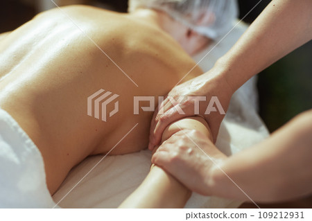 Closeup on massage therapist in spa salon massaging clients arm Closeup on massage therapist in spa salon massaging clients arm 109212931