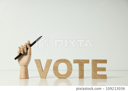 Wooden letters and hand with pen on light background, space for text 109213036