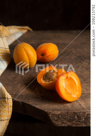 Apricot fruit whole and half on wooden background.. 109213792