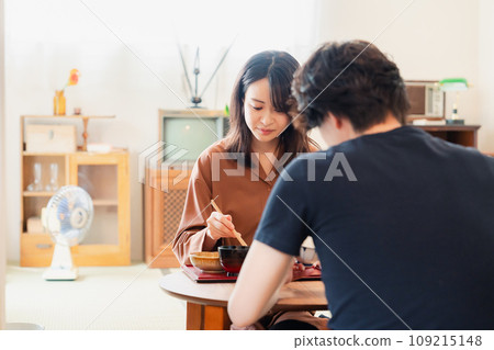 一對年輕夫婦在餐桌上吃晚飯,復古的氣氛讓人想起戲劇。 一對年輕夫婦在餐桌上吃晚飯,復古的氣氛讓人想起戲劇。 109215148