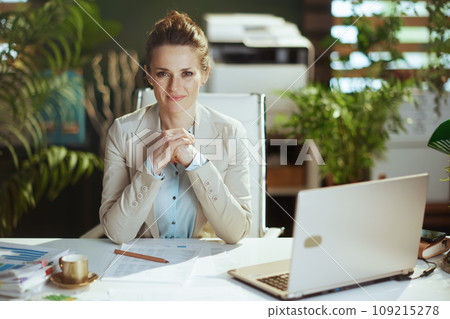 Portrait of woman worker in light business suit in green office 109215278