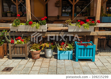 Town flowers in the big wooden pots on street. Interior street cafe with flowers in wooden pot Town flowers in the big wooden pots on street. Interior street cafe with flowers in wooden pot 109215299