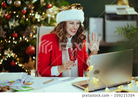 smiling using video chat in green office with Christmas tree 109215384