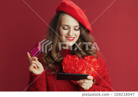 pensive stylish woman in sweater and beret buying online 109216047
