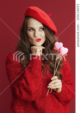 pensive stylish female in red sweater and beret 109216055