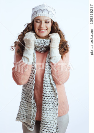 smiling trendy female wrapping up in scarf on white smiling trendy female wrapping up in scarf on white 109216257