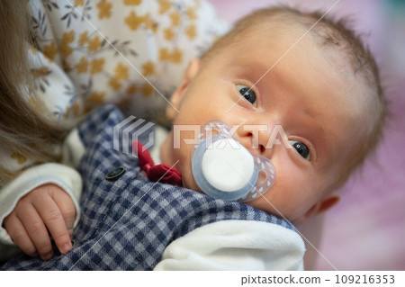 Face of a newborn baby with a pacifier. Face of a newborn baby with a pacifier. 109216353