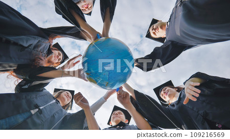 Graduating students twirl a geographic globe of the world in their hands. Graduating students twirl a geographic globe of the world in their hands. 109216569