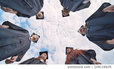 College students stand in a circle wearing black robes. College students stand in a circle wearing black robes. 109216626