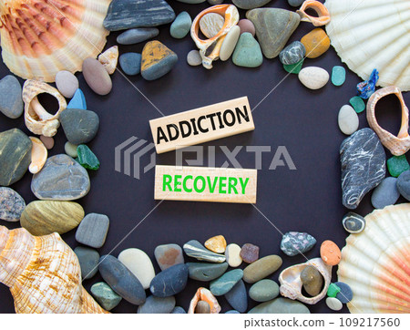 Addiction recovery symbol. Concept words Addiction recovery on beautiful wooden blocks. Beautiful black table black background. Sea shell sea stone. Psychology addiction recovery concept. Copy space. Addiction recovery symbol. Concept words Addiction recovery on beautiful wooden blocks. Beautiful black table black background. Sea shell sea stone. Psychology addiction recovery concept. Copy space. 109217560