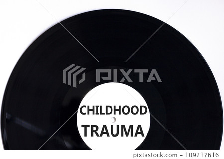 Childhood trauma symbol. Concept words Childhood trauma on beautiful black vinyl disk. Beautiful white table white background. Business psychology childhood trauma concept. Copy space. 109217616