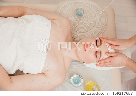 A cosmetologist woman gives a facial massage to a client A cosmetologist woman gives a facial massage to a client 109217698