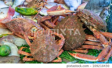 Stall at the Essaouira fish market with a variety of fresh crabs and seafood. Fishermen clean and prepare the catch, offering the coastal traditions that define Essaouira's culinary culture. 109218430