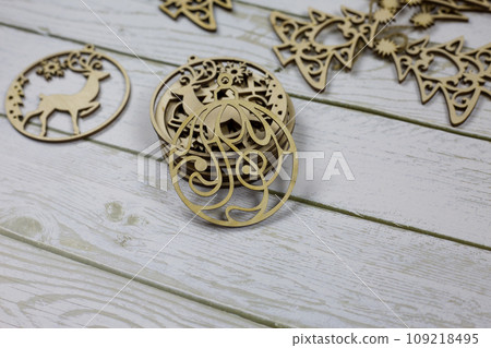 Flat wooden toy in the shape of a circle with a pattern for decorating a Christmas tree for the New Year Flat wooden toy in the shape of a circle with a pattern for decorating a Christmas tree for the New Year 109218495