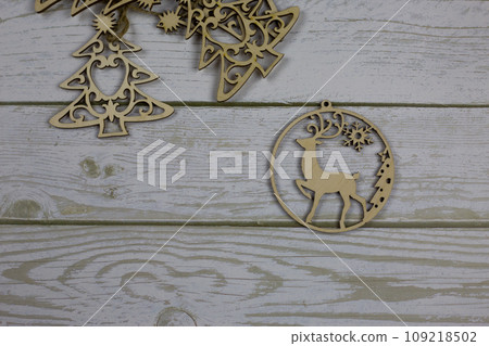 Flat wooden toy with a deer for decoration for the New Year lies on a white wooden table Flat wooden toy with a deer for decoration for the New Year lies on a white wooden table 109218502