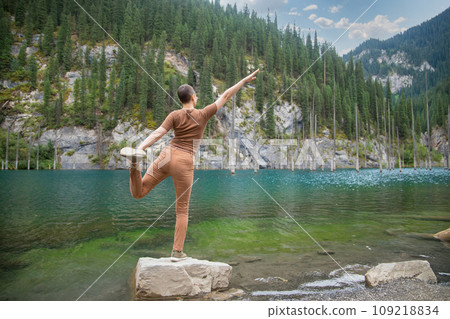 Woman retreat on Kaindy lake. Picturesque nature of Kazakhstan in Almaty region Woman retreat on Kaindy lake. Picturesque nature of Kazakhstan in Almaty region 109218834