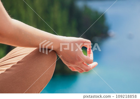 Close-up yoga hands. Woman exercising meditation outdoors nature background. Healthy and Yoga Concept Close-up yoga hands. Woman exercising meditation outdoors nature background. Healthy and Yoga Concept 109218858
