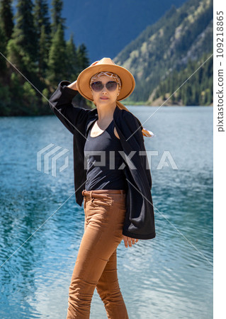Woman tourist vertical portrait look at camera on Kolsay lake in Kolsai Koldery gorge, nature of Kazakhstan National Park 109218865