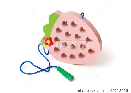 Pink wooden children's educational toy in the shape of a strawberry with a funny worm on a rope, isolated on white background 109218906