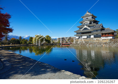 Matsumoto Castle in autumn leaves and the scenery reflected on the water surface, the mountain range of the Northern Alps Matsumoto Castle in autumn leaves and the scenery reflected on the water surface, the mountain range of the Northern Alps 109220267