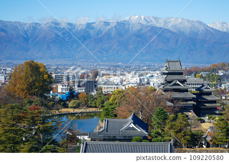 Matsumoto Castle in autumn leaves and the Northern Alps in snow, view from Matsumoto City Hall 109220580