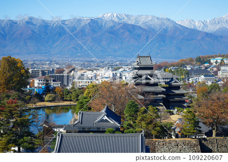 Matsumoto Castle in autumn leaves and the Northern Alps in snow, view from Matsumoto City Hall 109220607