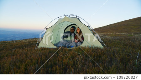 African American man kisses Caucasian woman, closes enter of tent 109220827