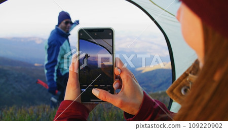 Woman takes a photo of tourist on mountain scenery 109220902