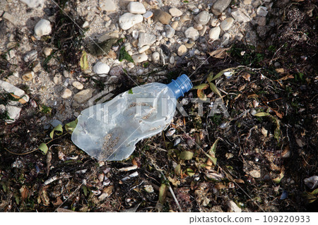 Plastic bottle discarded on pebble coast 109220933