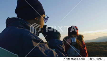 Young couple of hikers rests and enjoys of view on top of hill 109220979