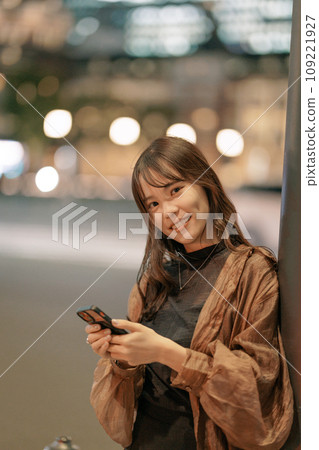 A woman looking at a smartphone in the city A woman looking at a smartphone in the city 109221927